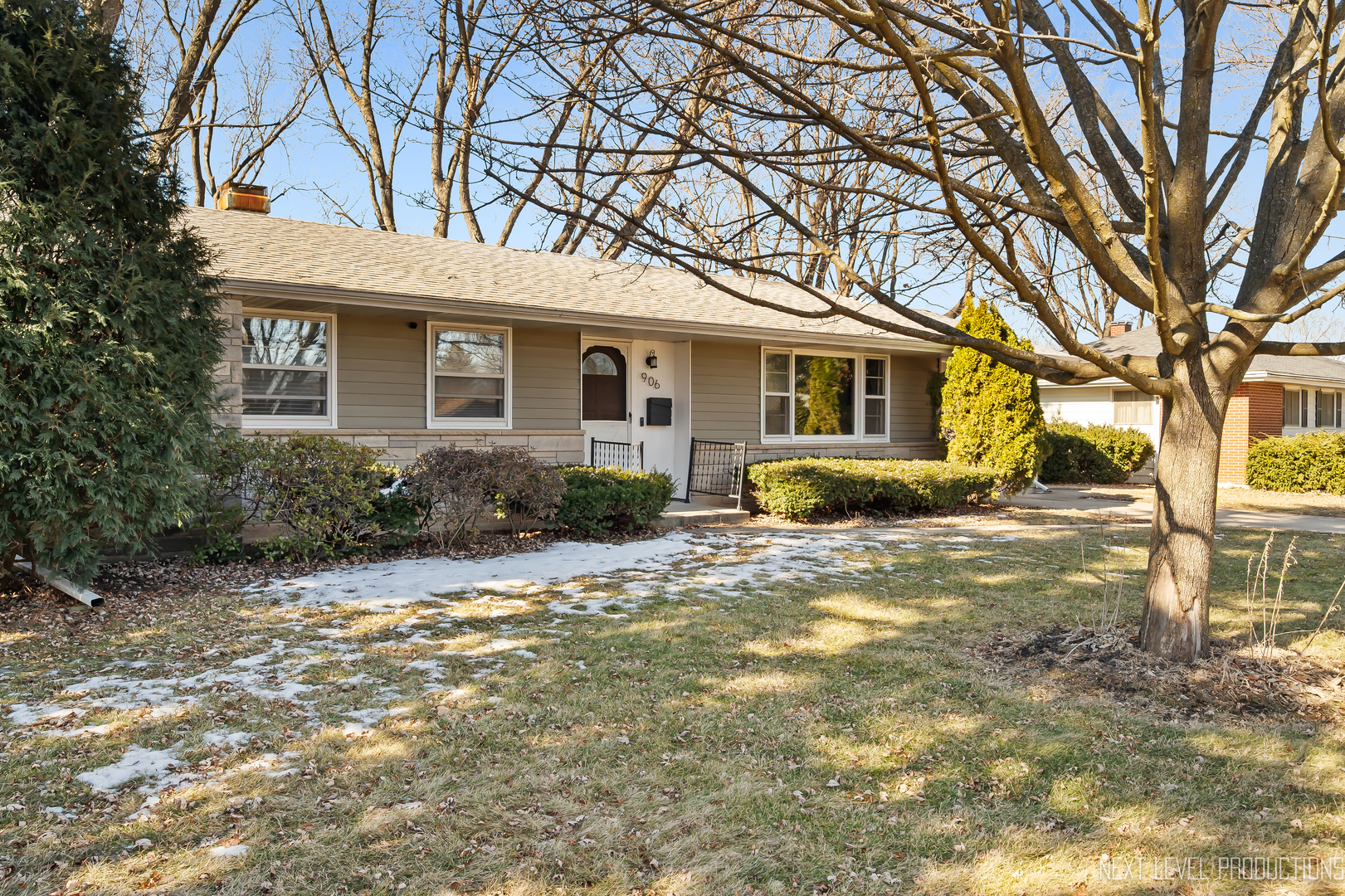 a front view of house with yard and trees around