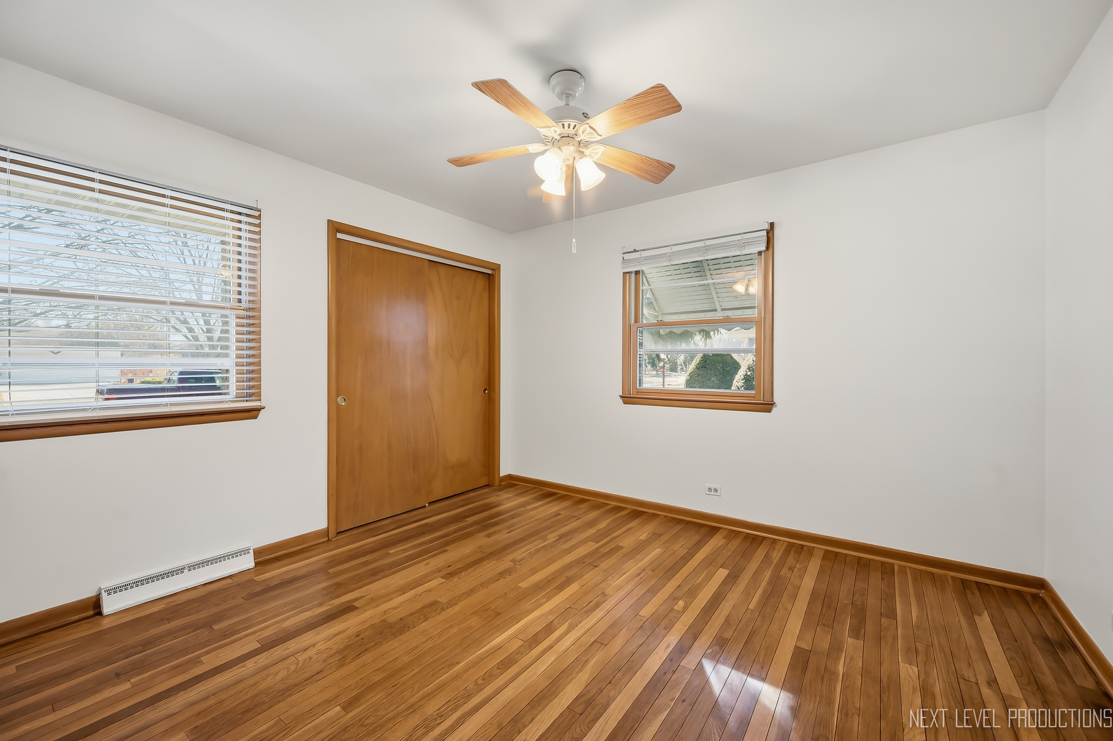 906 Carol Avenue Elgin, IL 60123 - Photo 13 of 31 a view of an empty room with wooden floor and a ceiling fan