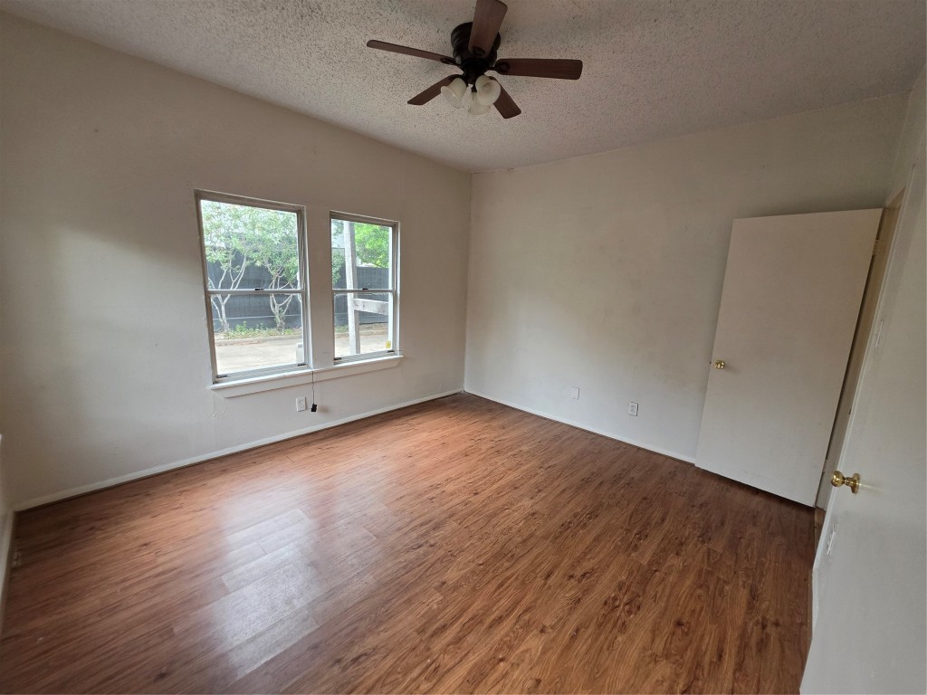 1226 West Gray Street, Unit 2 Houston, TX 77019 - Photo 10 of 14 an empty room with wooden floor ceiling fan and windows