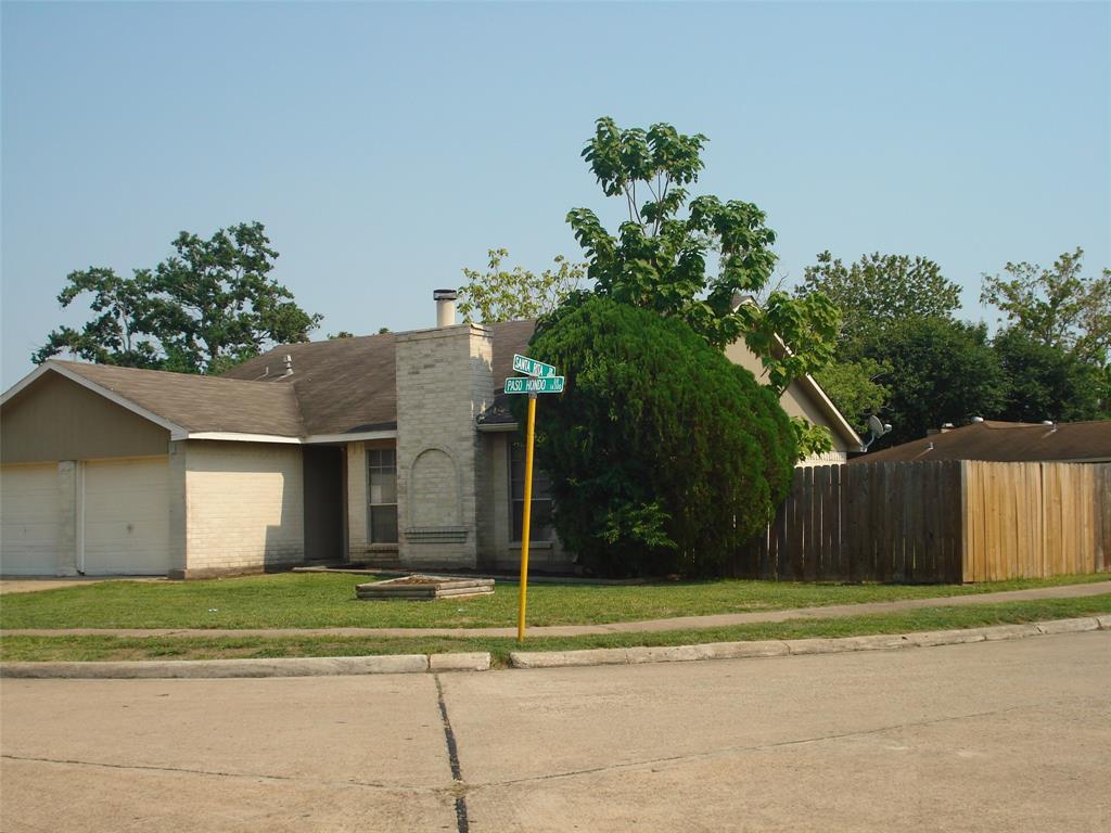 a view of a house with a yard and a basketball court