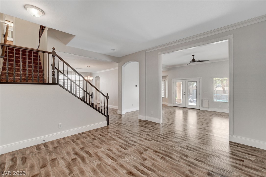 191 Verde Ridge Court Henderson, NV 89012 - Photo 2 of 36 Unfurnished living room with stairway, crown molding, wood finished floors, ceiling fan, and baseboards