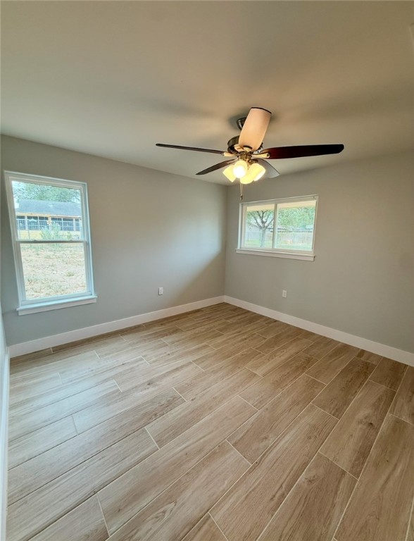 3939 Harvey Robstown, TX 78380 - Photo 10 of 17 an empty room with wooden floor fan and windows
