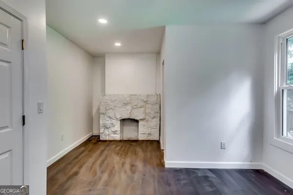 a view of empty room with wooden floor and fireplace