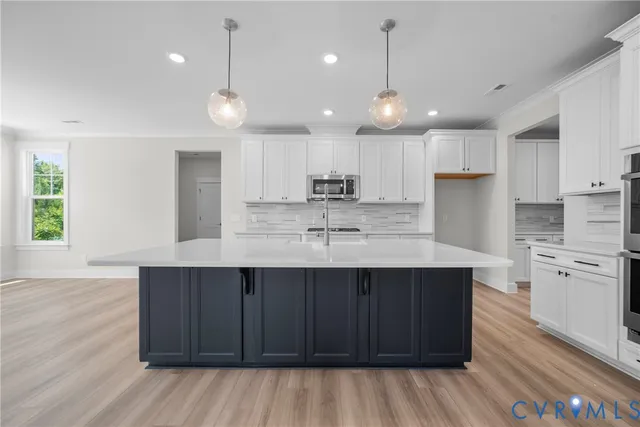a kitchen with stainless steel appliances granite countertop a sink refrigerator and cabinets