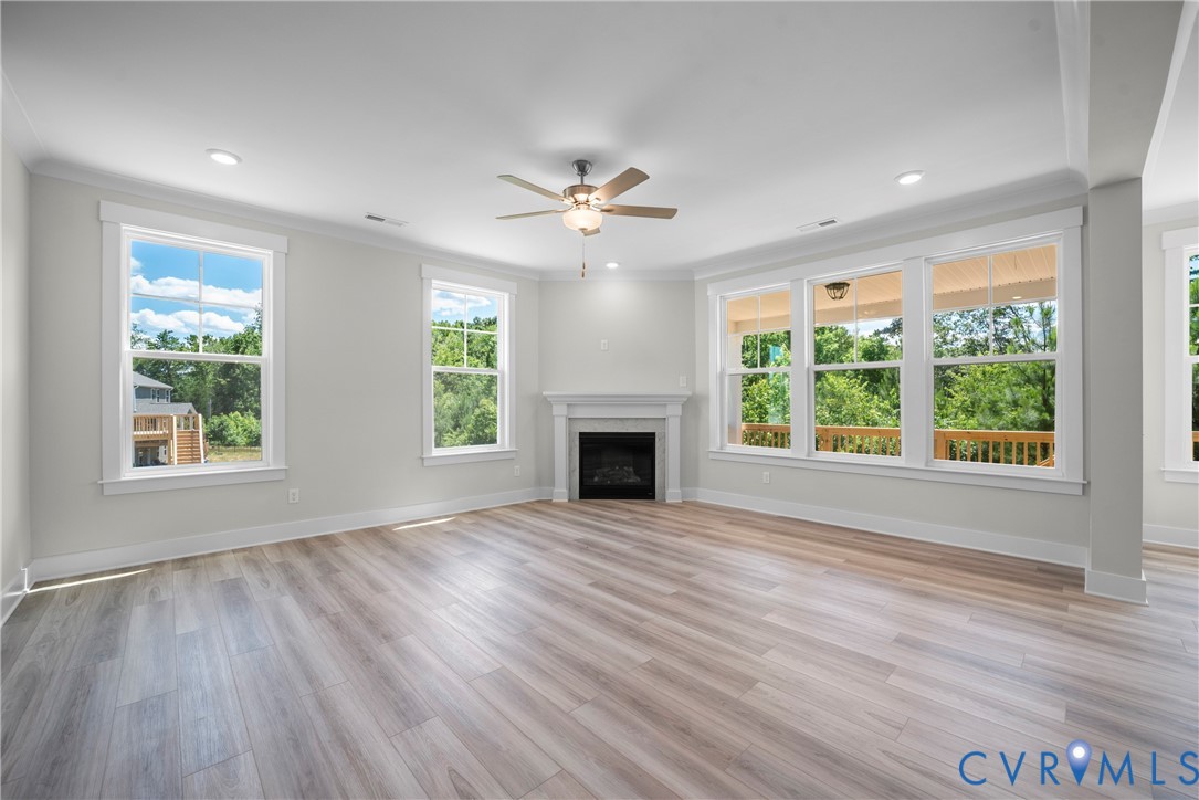 3917 Jett Court Gum Spring, VA 23065 - Photo 5 of 12 an empty room with windows a fireplace and a chandelier fan