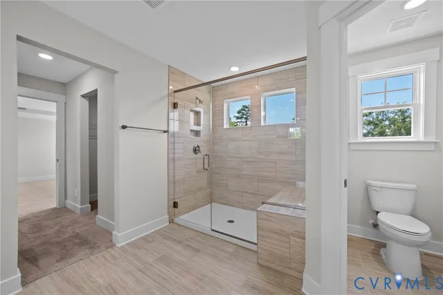 a bathroom with a toilet and a shower