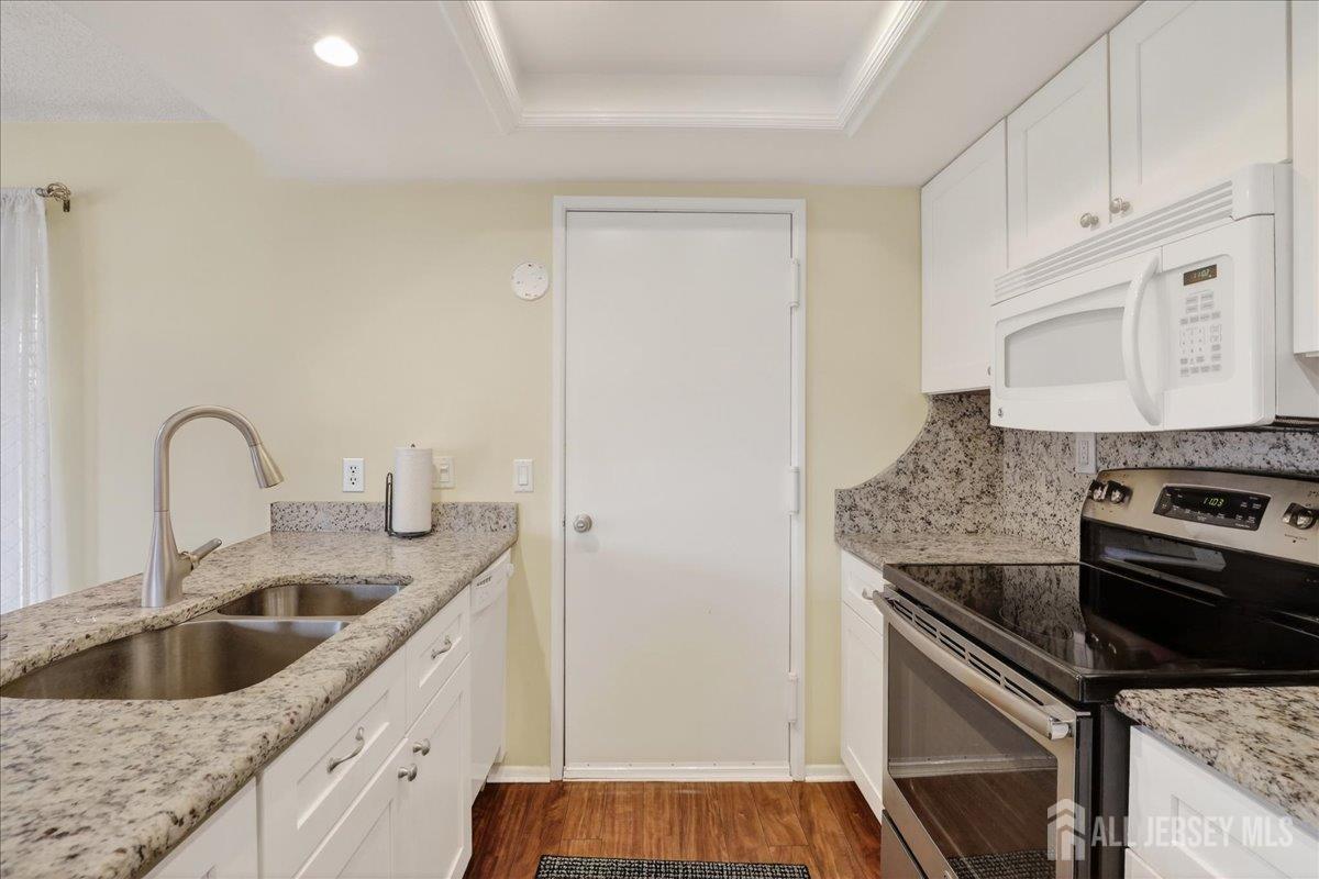 205A Newport Road, Unit A Monroe Township, NJ 08831 - Photo 11 of 26 a kitchen with granite countertop a sink and a stove top oven