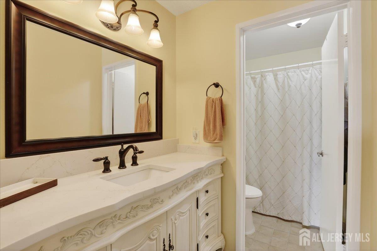 205A Newport Road, Unit A Monroe Township, NJ 08831 - Photo 16 of 26 a bathroom with a double vanity sink and a mirror