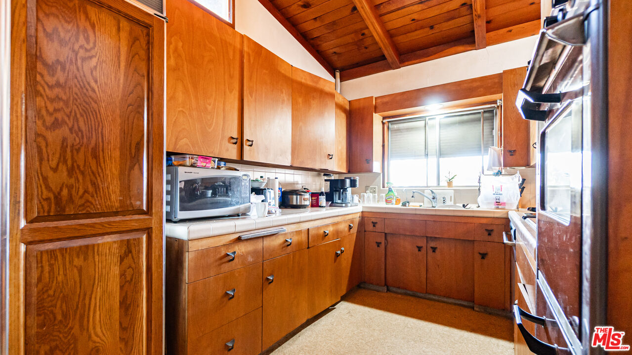 1408 251st Street Harbor City, CA 90710 - Photo 9 of 40 a kitchen with stainless steel appliances granite countertop cabinets and window