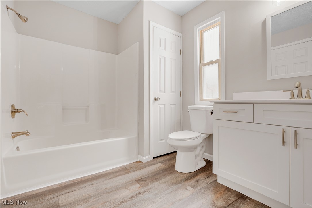 1893 Benjamin Road Madison, OH 44057 - Photo 6 of 23 Bathroom with shower combination, toilet, wood finished floors, and vanity