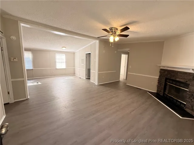 a view of a livingroom with a flat screen tv wooden floor and a ceiling fan