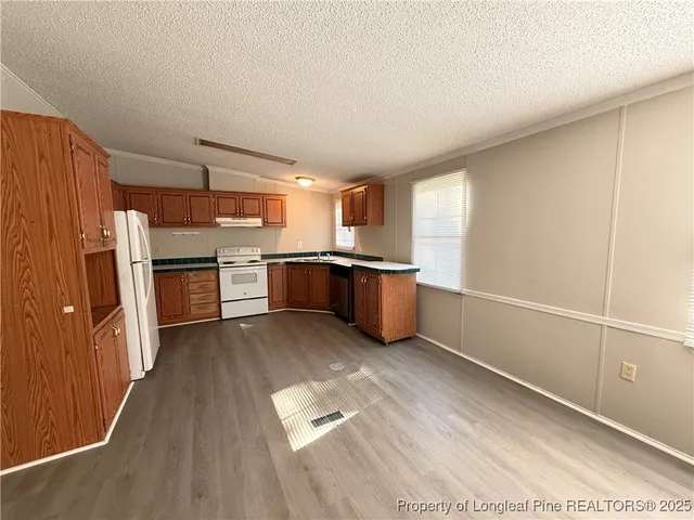 a kitchen with stainless steel appliances granite countertop a refrigerator and a stove top oven