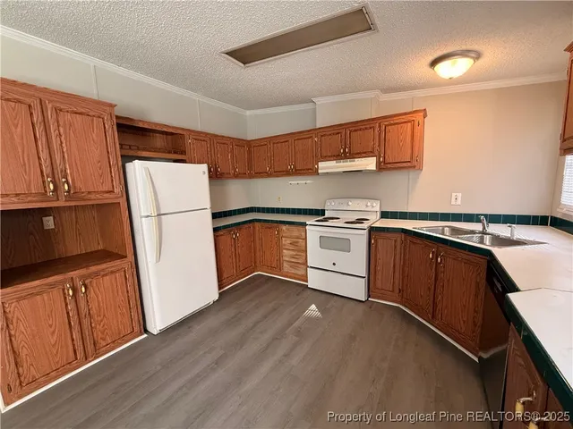 a kitchen with a refrigerator sink and wooden cabinets