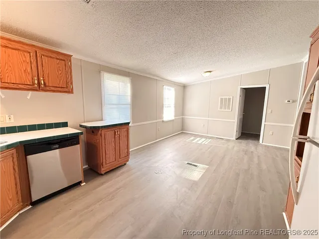 a view of a kitchen with wooden floor and electronic appliances