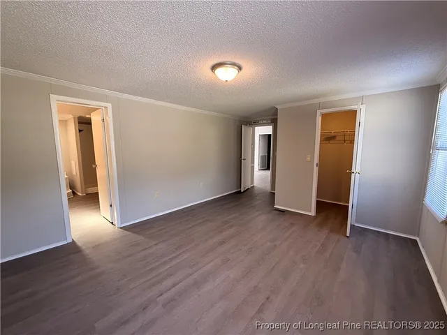 an empty room with wooden floor and closet