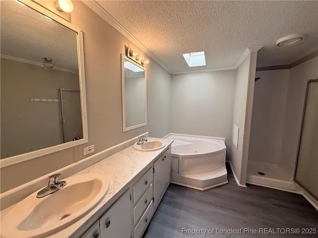 a spacious bathroom with a double vanity sink a mirror and a bathtub