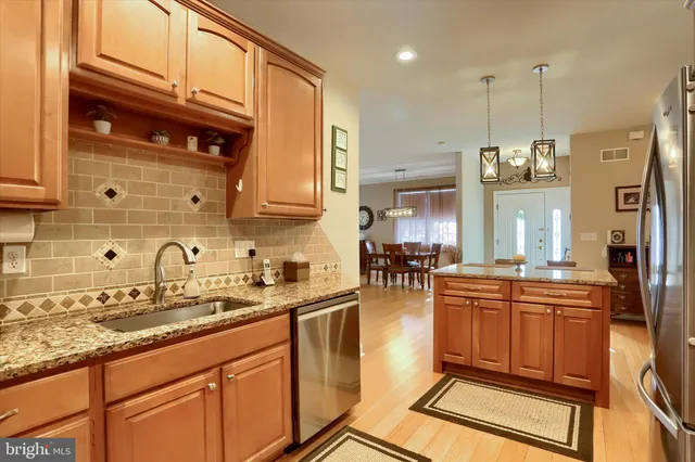 a kitchen with stainless steel appliances granite countertop a sink a stove counter space and cabinets