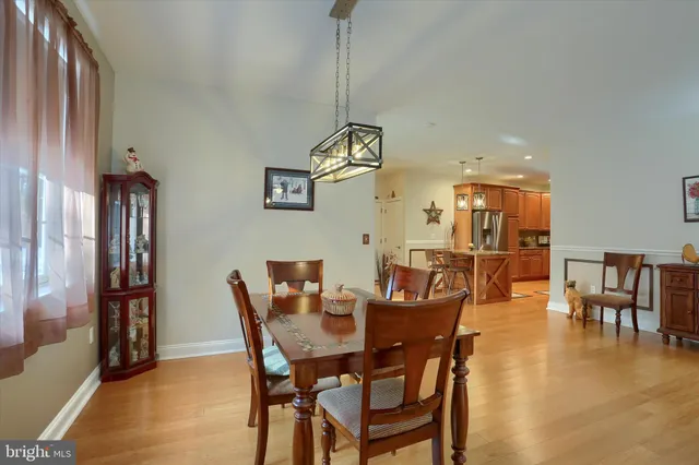 a dining room with furniture entryway and wooden floor
