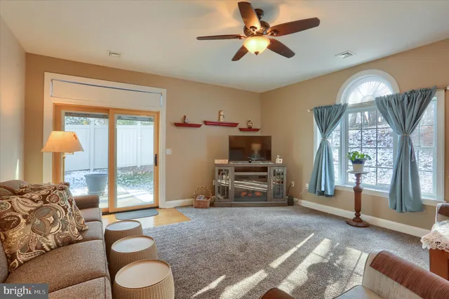 a living room with furniture a flat screen tv and a large window