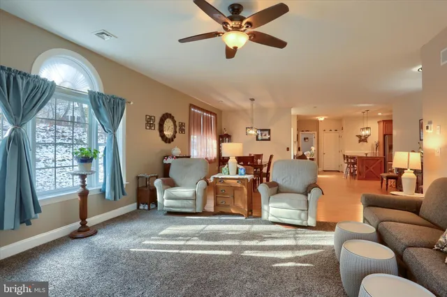 a living room with furniture chandelier and a large window