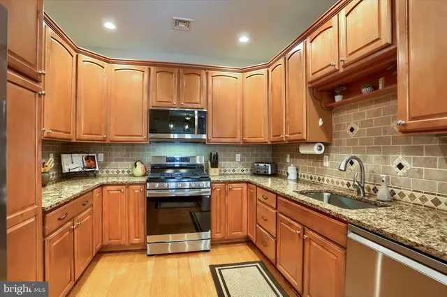 a kitchen with stainless steel appliances granite countertop a stove sink microwave and cabinets