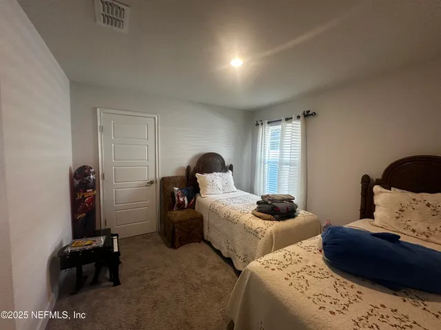 a bedroom with two bed and a window