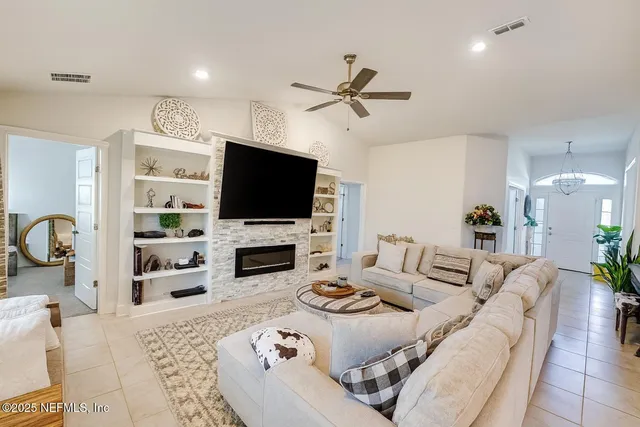 a living room with furniture a flat screen tv and a fireplace
