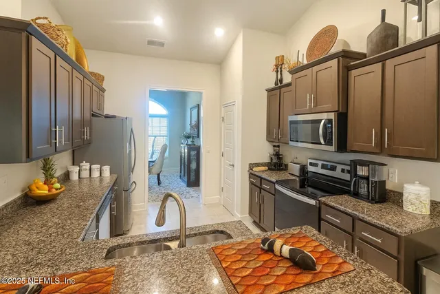 a kitchen with stainless steel appliances granite countertop a sink stove and refrigerator