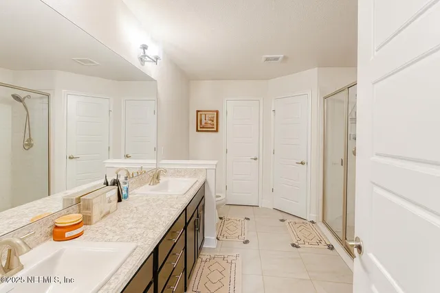 a bathroom with a granite countertop sink a large mirror and shower