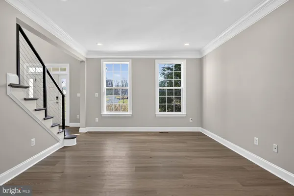 an empty room with wooden floor fireplace and windows