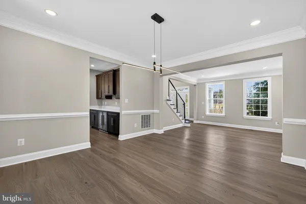 a view of a room with wooden floor ceiling fan and window