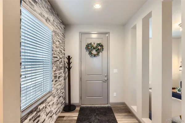 a view of a hallway with wooden floor and a bathroom