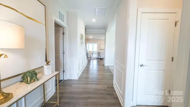 a view of a hallway with wooden floor and staircase
