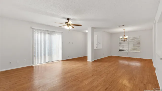 an empty room with wooden floor and window