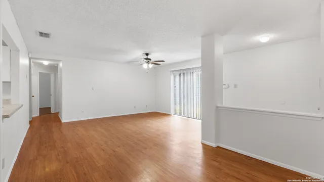 a view of an empty room with wooden floor