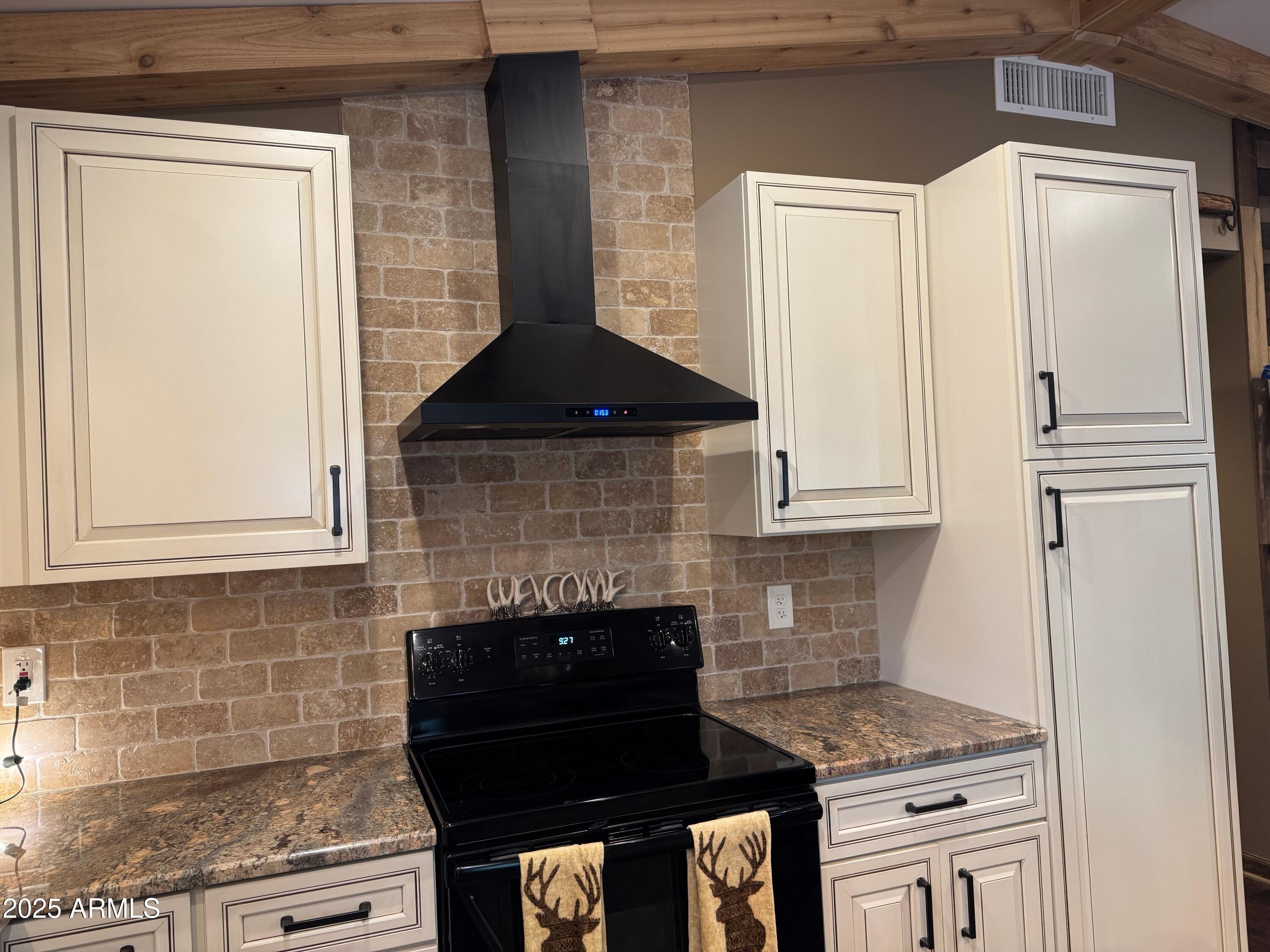 3998 Bloody Basin Road Pine, AZ 85544 - Photo 65 of 71 a kitchen with granite countertop a stove top oven and cabinets