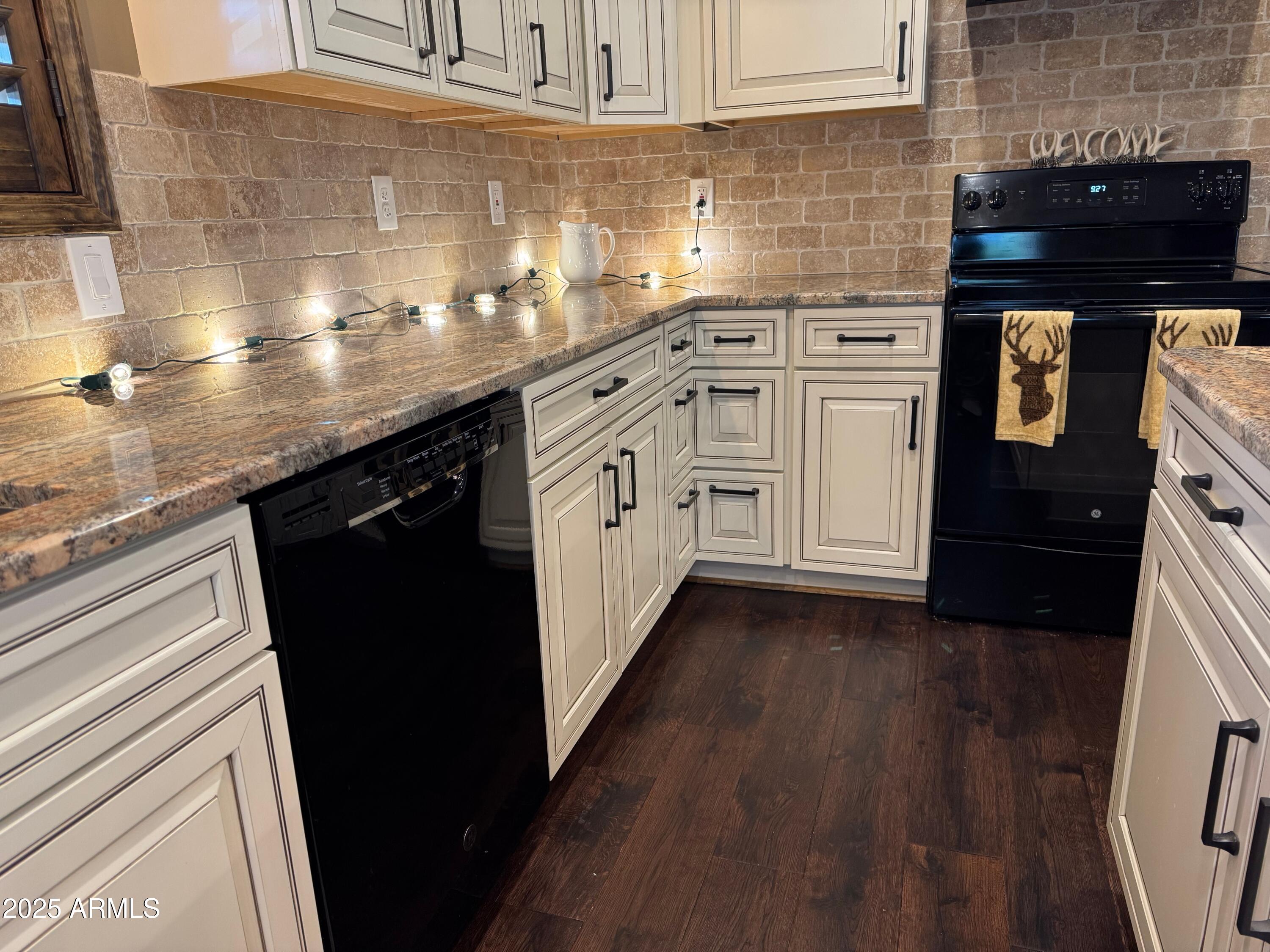 3998 Bloody Basin Road Pine, AZ 85544 - Photo 66 of 71 a kitchen with granite countertop white cabinets and black appliances