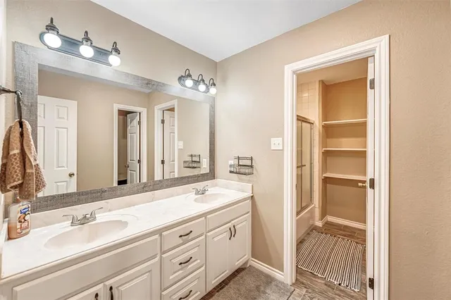 a spacious bathroom with a double vanity sink and a mirror