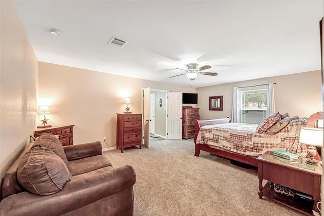 a spacious bedroom with a bed a couch and dresser