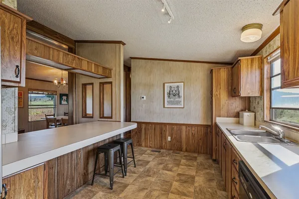a kitchen with stainless steel appliances granite countertop a sink and wooden cabinets