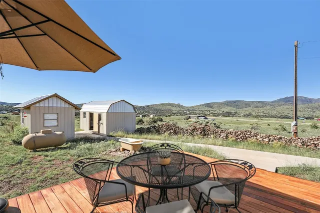 an aerial view of a house with a yard and table and chairs under an umbrella