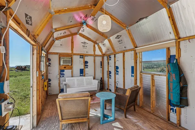a living room with furniture a flat screen tv and a large window