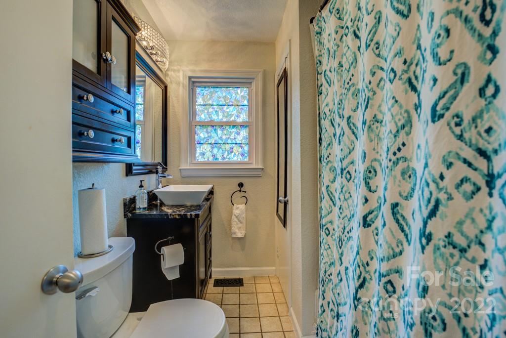 292 Brookside Camp Road Hendersonville, NC 28792 - Photo 16 of 41 a bathroom with a toilet and a shower curtain