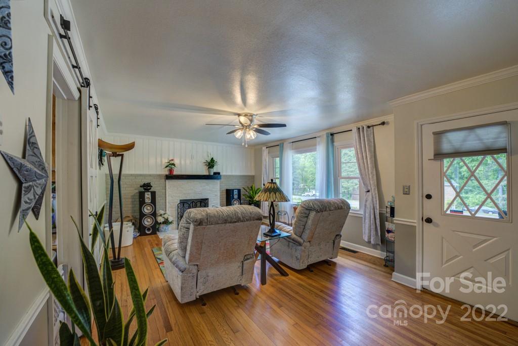 292 Brookside Camp Road Hendersonville, NC 28792 - Photo 2 of 41 a living room with furniture fireplace and wooden floor
