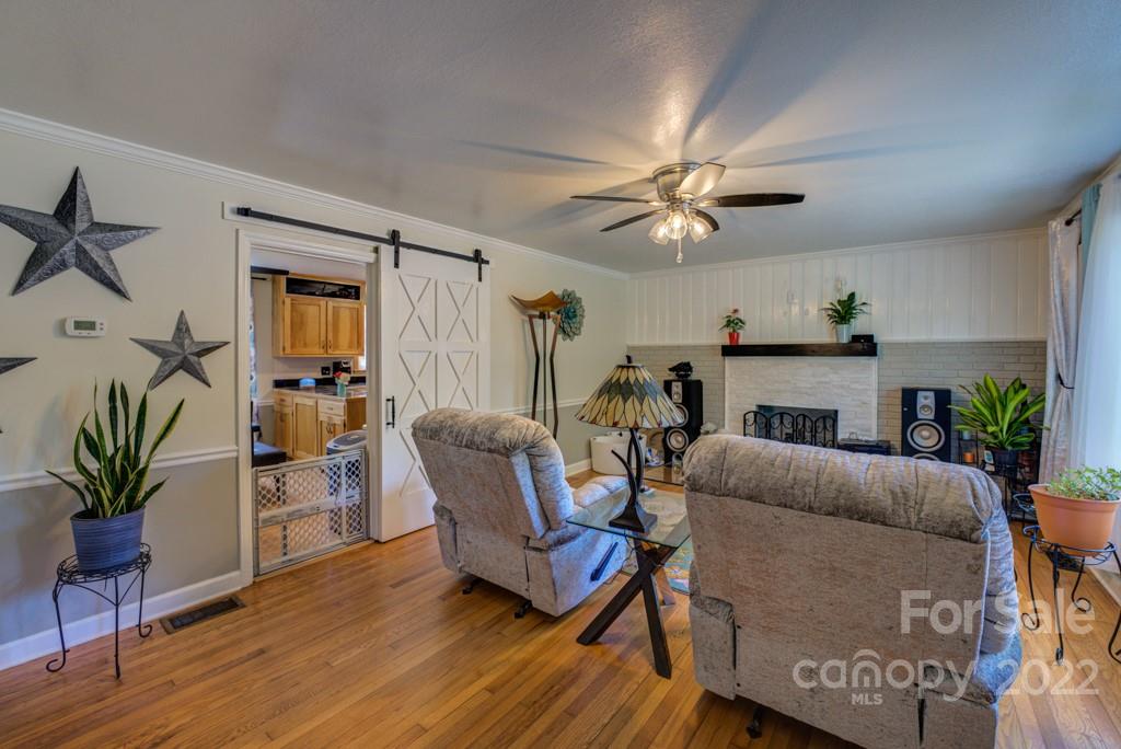 292 Brookside Camp Road Hendersonville, NC 28792 - Photo 3 of 41 a living room with furniture a fireplace and a potted plant