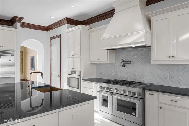 a spacious bedroom with a bed and ceiling chandelier