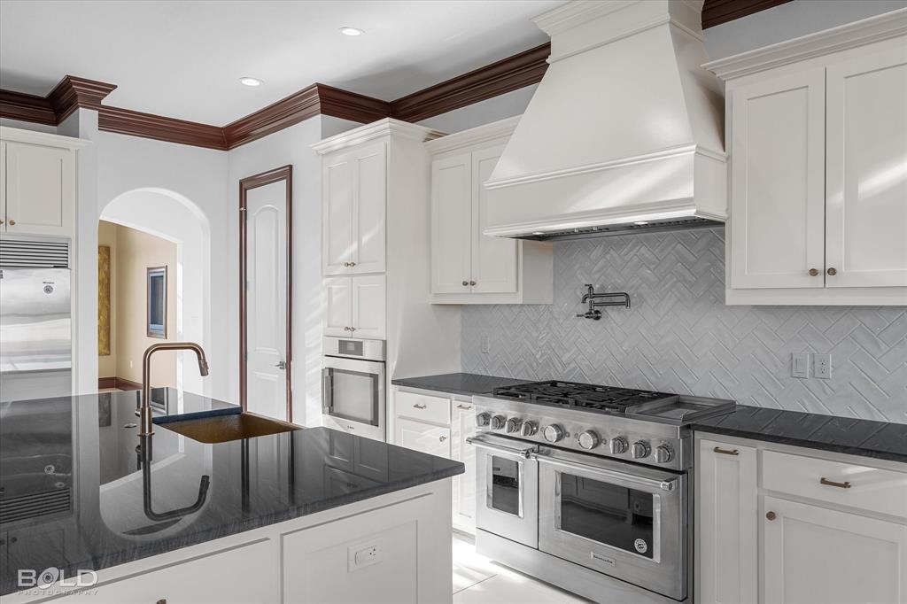 9480 McCain Road Shreveport, LA 71107 - Photo 16 of 40 a kitchen with a stove and white cabinets
