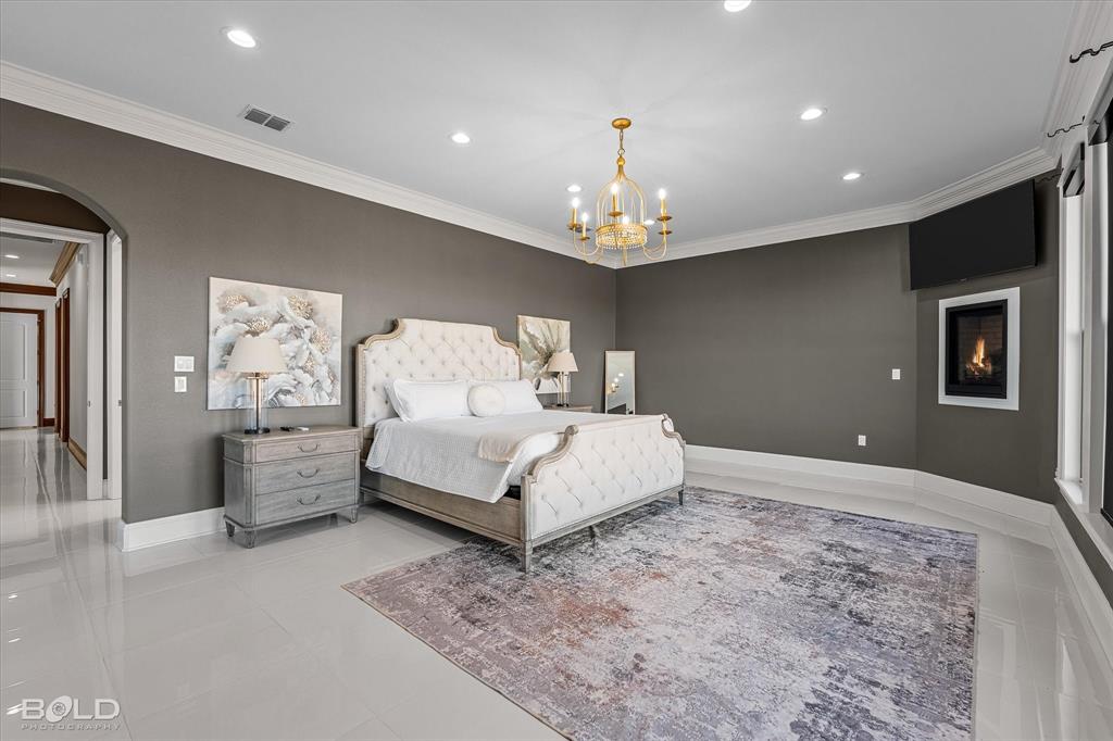 9480 McCain Road Shreveport, LA 71107 - Photo 17 of 40 a spacious bedroom with a bed and ceiling chandelier