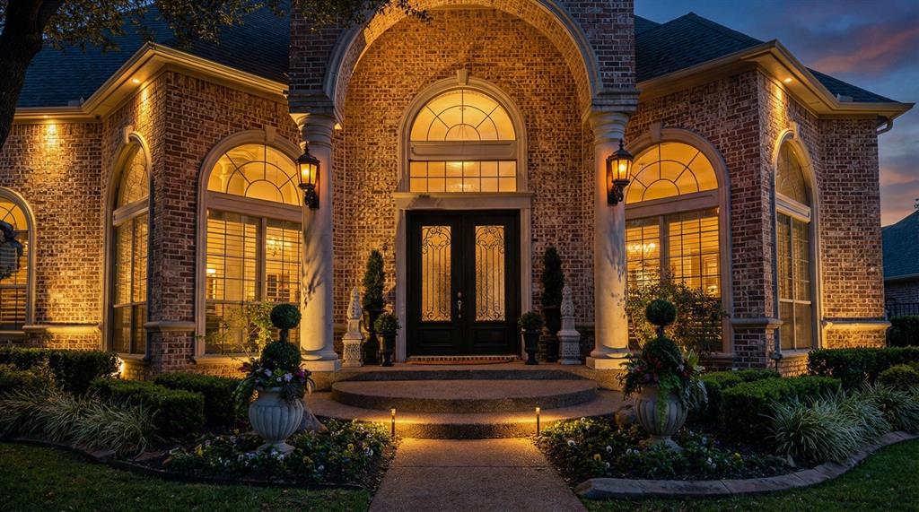 Exterior entry at dusk featuring french doors and brick siding