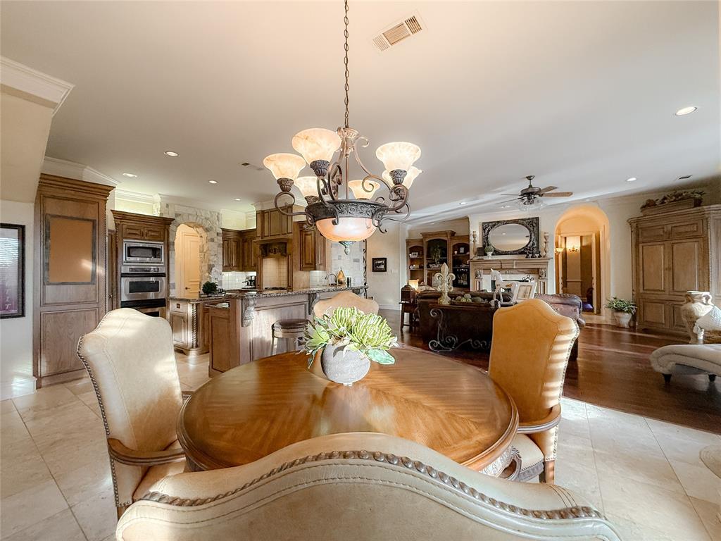 1919 Kings Pass Heath, TX 75032 - Photo 17 of 38 Dining space featuring arched walkways, hanging lights, crown molding, a ceiling fan, and a fireplace